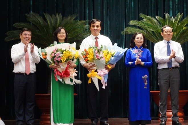 Ông Lê Hoà Bình và bà Phan Thị Thắng nhận hoa chúc mừng từ lãnh đạo TPHCM.