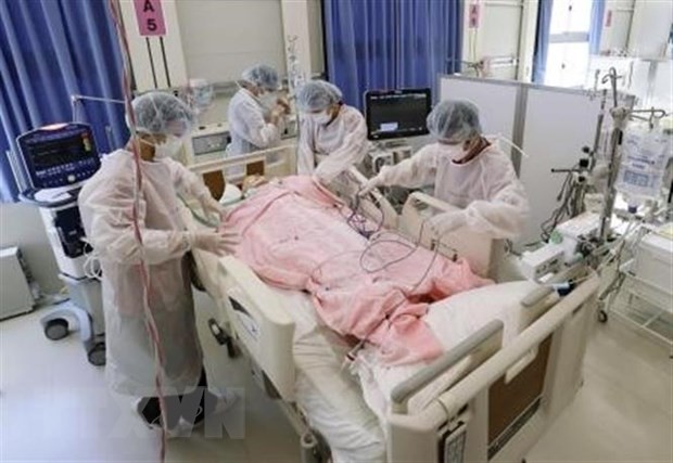 Nhân viên y tế điều trị cho bệnh nhân COVID-19 tại bệnh viện dã chiến ở Osaka, Nhật Bản. (Ảnh: Kyodo/TTXVN).