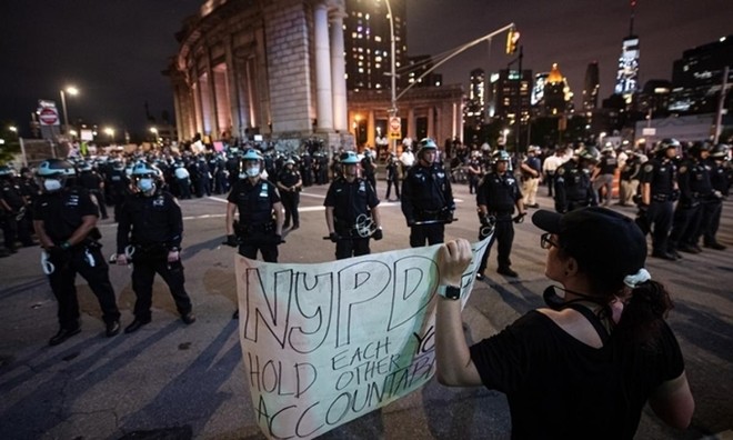 Người biểu tình đối mặt lực lượng an ninh ở New York trong thời gian áp lệnh giới nghiêm tối 2/6. Ảnh: Reuters.