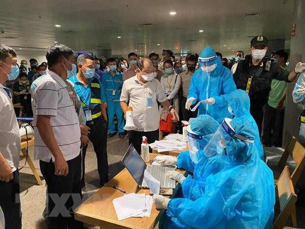 Nhân viên y tế làm thủ tục lấy mẫu xét nghiệm cho người làm việc tại sân bay Tân Sơn Nhất, ngày 6/2. (Ảnh: TTXVN phát).