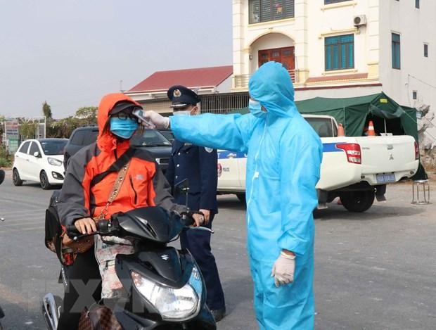 Đo thân nhiệt người dân ở chốt kiểm soát dịch bệnh tại Bắc Ninh. (Ảnh: Thái Hùng/TTXVN).