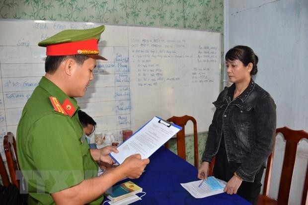 Cơ quan Cảnh sát điều tra Công an tỉnh tống đạt quyết định khởi tố bị can Nguyễn Thị Thanh Thúy. (Ảnh Công Trí/TTXVN).