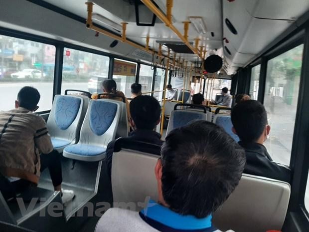 Hành khách đeo khẩu trang và được bố trí ngồi giãn cách theo đúng quy định khi đi xe buýt. (Ảnh: Việt Hùng/Vietnam+).