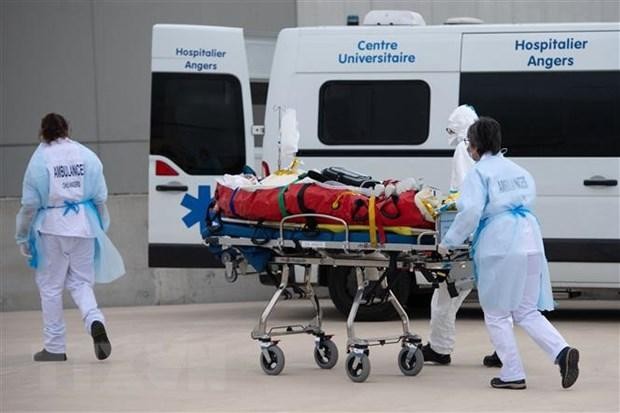 Nhân viên y tế chuyển bệnh nhân COVID-19 lên xe cứu thương tại Angers, Pháp ngày 15/3/2021. (Nguồn: AFP/TTXVN).