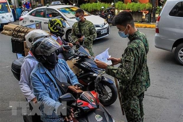 Cảnh sát làm nhiệm vụ tại một chốt kiểm tra y tế nhằm ngăn chặn sự lây lan của COVID-19 ở Manila, Philippines. (Ảnh: THX/TTXVN).