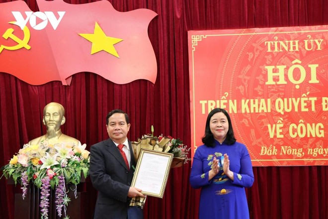 Ủy viên Trung ương Đảng, Trưởng Ban Dân vận Trung ương Bùi Thị Minh Hoài trao Quyết định và tặng hoa, chúc mừng ông Điểu K’Ré.