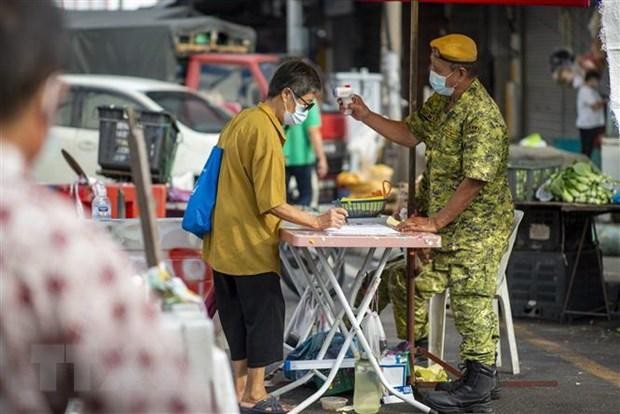 Kiểm tra thân nhiệt phòng dịch COVID-19 tại một khu chợ ở Kuala Lumpur, Malaysia, ngày 7/5/2021. (Ảnh: THX/TTXVN)