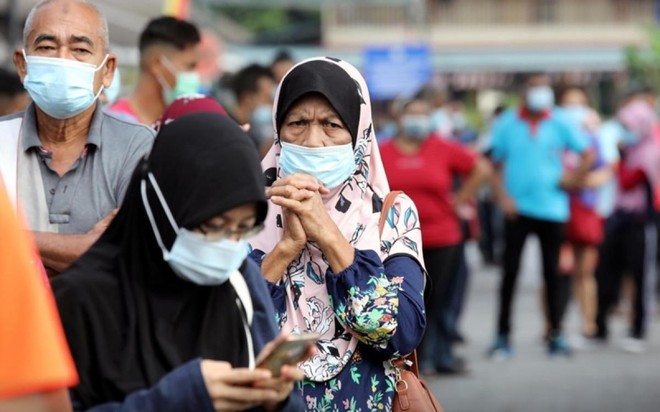 Người dân xếp hàng chờ làm xét nghiệm tại thành phố Klang, Malaysia. (Ảnh: Reuters).