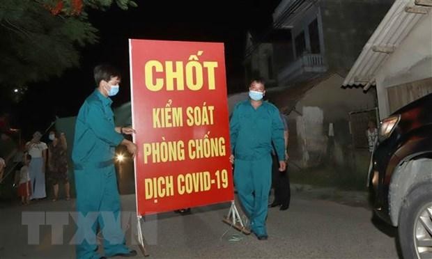 Lực lượng chức năng tiến hành tthu dọn vật dụng tại chốt cách ly tại thôn Tiền Phong, xã Tân Phong, huyện Bình Xuyên, Vĩnh Phúc. (Ảnh: Hoàng Hùng/TTXVN).