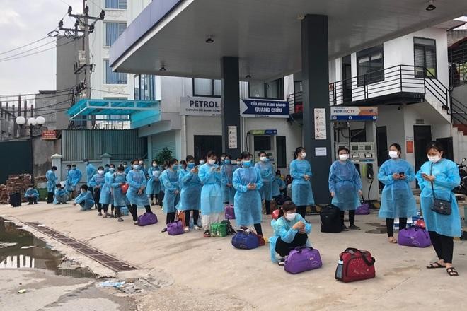 Công nhân ở trọ tại ổ dịch thôn Núi Hiểu, xã Quang Châu, huyện Việt Yên, chờ lên xe ô tô di chuyển đến khu cách ly tập trung của huyện.