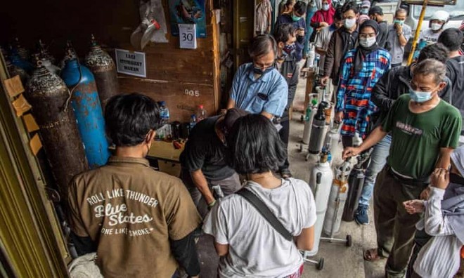Người nhà của bệnh nhân Covid-19 xếp hàng để bơm đầy bình oxy ở Manggarai, Jakarta. Ảnh: Shutterstock.
