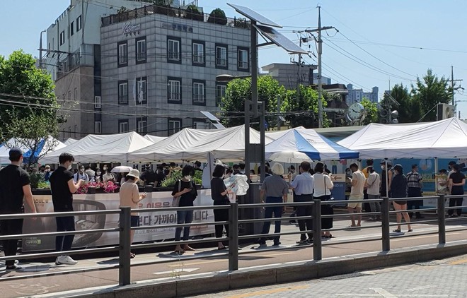 Người dân xếp hàng xét nghiệm COVID-19 trong thời tiết nắng nóng ở quận Seongbuk, Seoul. (Ảnh: Mạnh Hùng/TTXVN).