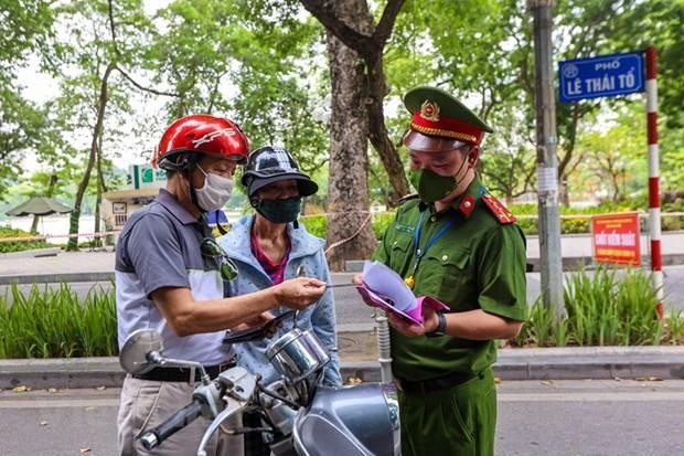 Lực lượng chức năng nhắc nhở người dân thực hiện nghiêm công tác phòng, chống dịch. (Ảnh: Minh Sơn/Vietnam+).