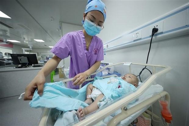 Nhân viên y tế chăm sóc trẻ mới sinh tại bệnh viện ở tỉnh Quý Châu (Trung Quốc), ngày 11/5/2021. (Ảnh: AFP/TTXVN).