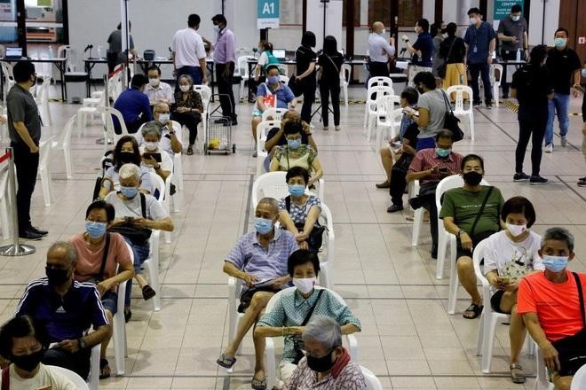 Người dân chờ đợi tiêm vắc xin Covid-19 ở Singapore (Ảnh: Reuters).