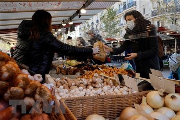 Người dân mua thực phẩm tại một khu chợ ở Paris, Pháp. (Ảnh: AFP/TTXVN).