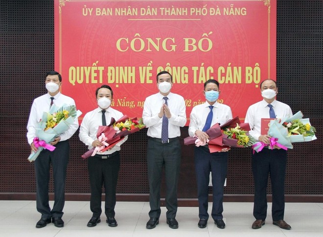 Ông Lê Trung Chinh (giữa), Chủ tịch UBND thành phố Đà Nẵng trao Quyết định và tặng hoa chúc mừng các cán bộ được điều động, bổ nhiệm vị trí công tác mới.