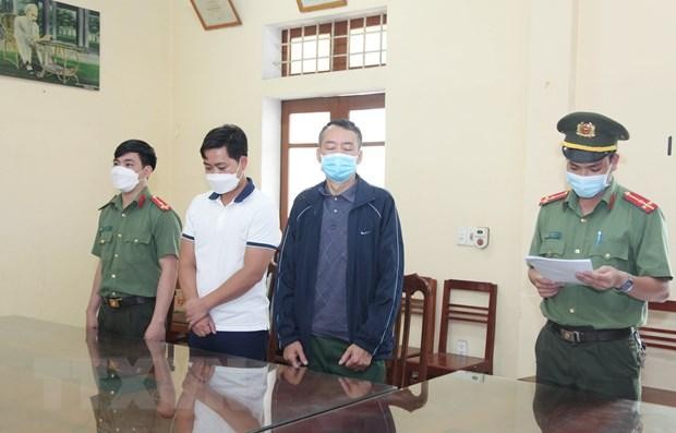 Cơ quan An ninh điều tra đọc lệnh bắt tạm giam đối tượng Khánh và An. (Ảnh: Hoàng Nguyên/TTXVN).