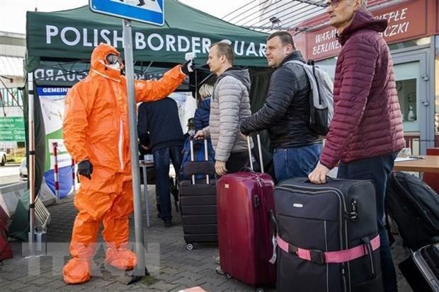 Nhân viên y tế kiểm tra thân nhiệt hành khách đi qua cửa khẩu biên giới Đức-Ba Lan. (Nguồn: AFP/TTXVN).