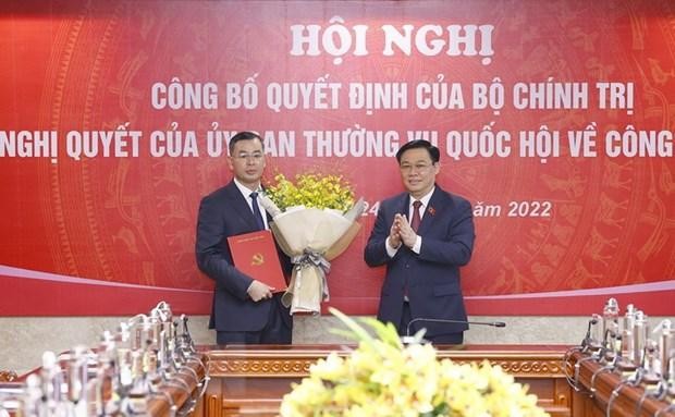 Chủ tịch Quốc hội Vương Đình Huệ trao Quyết định của Bộ Chính trị và tặng hoa ông Ngô Văn Tuấn. (Ảnh: Doãn Tấn/TTXVN).