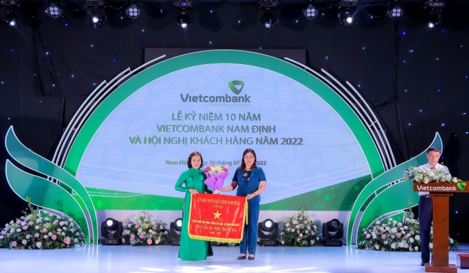 Thay mặt UBND tỉnh Nam Định, bà Hà Lan Anh - Phó Chủ tịch UBND tỉnh tặng Cờ “Đơn vị dẫn đầu phong trào thi đua” cho Vietcombank Nam Định.