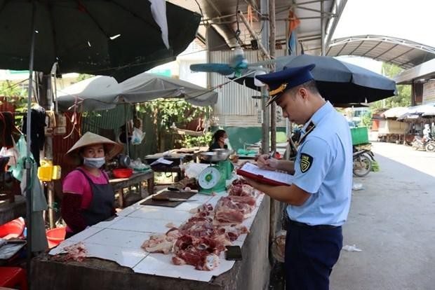 Lực lượng Quản lý thị trường tỉnh Lạng Sơn tuyên truyền, ký cam kết với hộ kinh doanh tại chợ Trung tâm thương mại thị trấn Đồng Đăng, huyện Cao Lộc. (Ảnh: PV/Vietnam+).