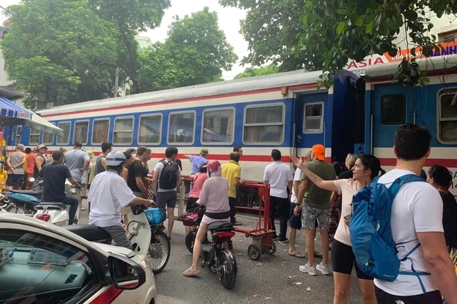 Sự việc khiến đoàn tàu khách Lào Cai - Hà Nội phải dừng lại gây ùn tắc giao thông (Ảnh: CTV).
