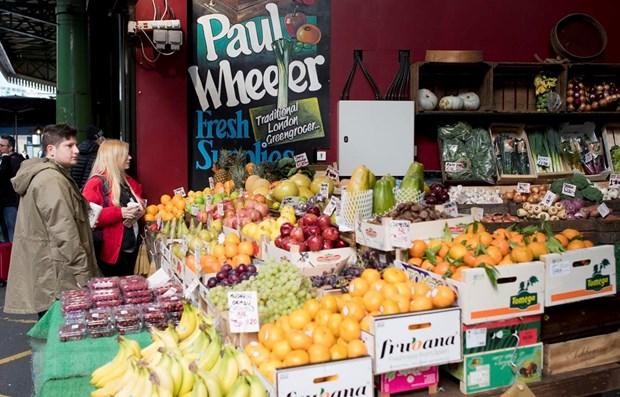 Khách hàng chọn mua hoa quả và rau tại một chợ ở London, Anh. (Ảnh: AFP/TTXVN).