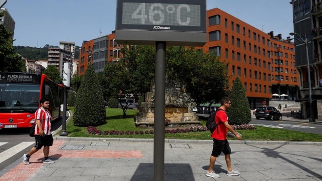 Người dân đi qua một biển báo nhiệt độ 46 độ C tại Bilbao, Tây Ban Nha ngày 17/6. (Ảnh: Reuters)