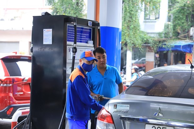 Nhân viên Petrolimex bán xăng cho khách hàng. (Ảnh: PV/Vietnam+).
