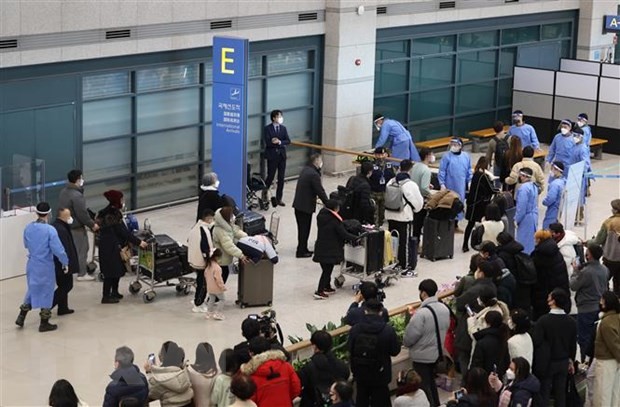 Du khách Trung Quốc được hướng dẫn tới khu vực kiểm dịch COVID-19 tại sân bay quốc tế Incheon, phía Tây Seoul (Hàn Quốc) ngày 2/1/2023. (Ảnh: AFP/TTXVN).
