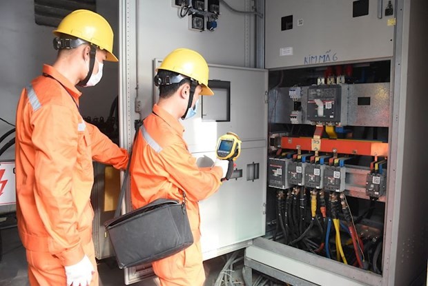 Nhân viên EVNHANOI kiểm tra vận hành thiết bị điện. (Ảnh: PV/Vietnam+).