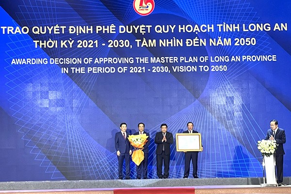 Được sự uỷ quyền của Thủ tướng Chính phủ, Bộ trưởng Bộ Kế hoạch và Đầu tư Nguyễn Chí Dũng (thứ hai từ phải qua) trao Quyết định phê duyệt quy hoạch cho lãnh đạo tỉnh Long An.