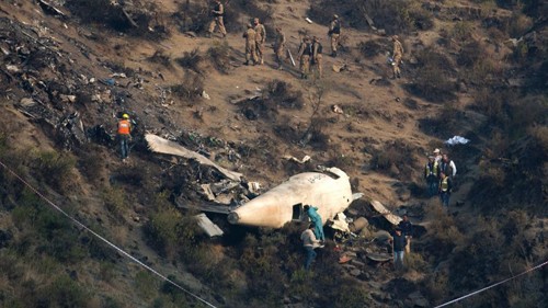 Các nhà điều tra Pakistan kiểm tra hiện trường máy bay rơi hôm qua. Ảnh: AP