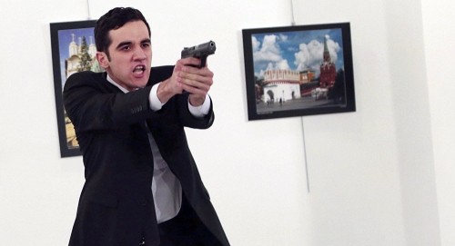 Mevlut Mert Altintas chĩa súng tại phòng triển lãm ảnh. Ảnh: AP
