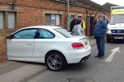 Chiếc BMW serie 1 màu trắng nằm gọn tronglỗ thủng do chính mình tạo ra. Ảnh:Reddit.