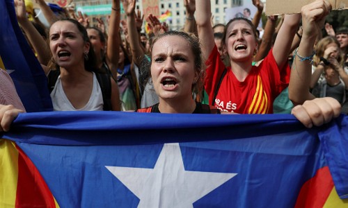 Một phụ nữ cầm cờ ly khai của Catalonia trên đường phố Barcelona hôm 2/10. Ảnh:Reuters.