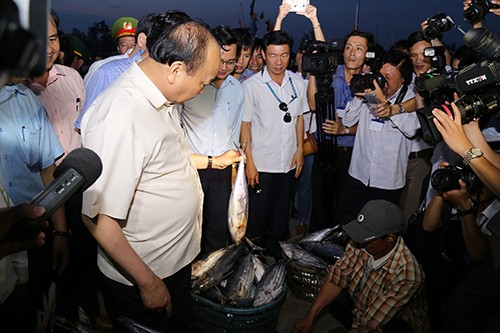 Thủ tướng hỏi thăm giá cả các loại cá, trực tiếp mua ba con cá ủng hộ ngư dân Quảng Trị. Ảnh:Hoàng Táo