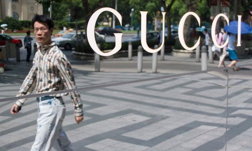 Một người đàn ông đi qua cửa hàng Gucci tại Thượng Hải, Trung Quốc. Ảnh:CNN