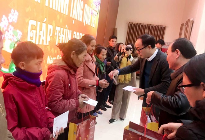 Ông Đặng Tuấn Khánh, Ủy viên Ban Biên tập Báo Đầu tư tặng quà cho người dân