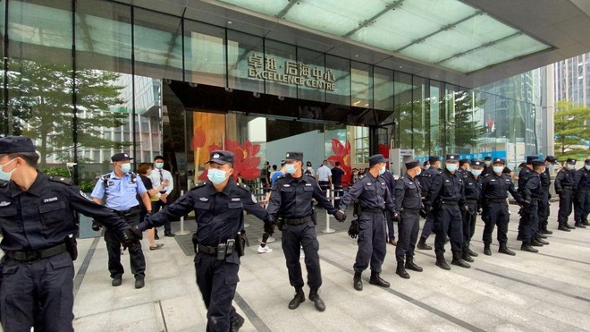 Các nhân viên an ninh tạo thành một chuỗi người khi họ bảo vệ trụ sở của Evergrande, nơi mọi người tụ tập để yêu cầu hoàn trả các khoản vay và các sản phẩm tài chính ở Thâm Quyến, Trung Quốc