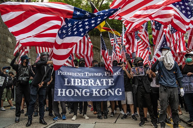 Người biểu tình vẫy cờ bên ngoài lãnh sự quán Mỹ ở Hồng Kông sau khi gửi đơnkêu cứu Tổng thống Mỹ Donald Trump. Ảnh: Getty Images.