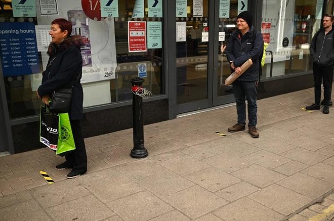 Người mua hàng tại Anh thực hiện giãn cách xã hội. Ảnh: AFP