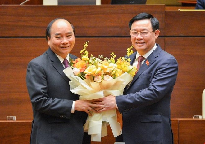 Thủ tướng Nguyễn Xuân Phúc (trái) nhận hoa chúc mừng của Chủ tịch Quốc hội Vương Đình Huệ (Ảnh Quochoi.vn).