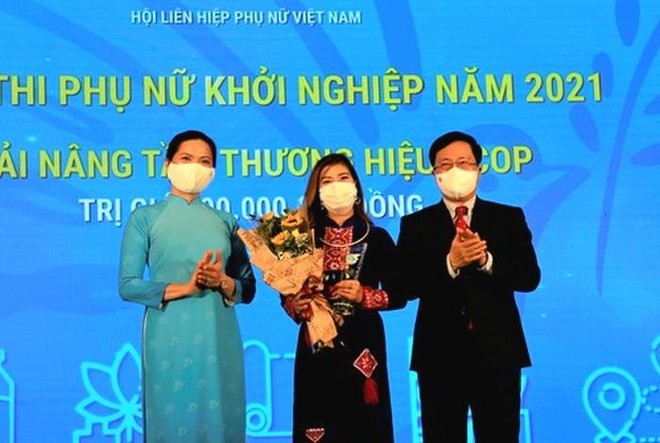 Phó Thủ tướng Thường trực Phạm Bình Minh và Chủ tịch Hội Liên hiệp Phụ nữ Việt Nam Hà Thị Nga trao Giải "Nâng tầm thương hiệu OCOP" cho tác giả Vi Thị Lụa với dự án "Trà diếp cá Lụa Vy"