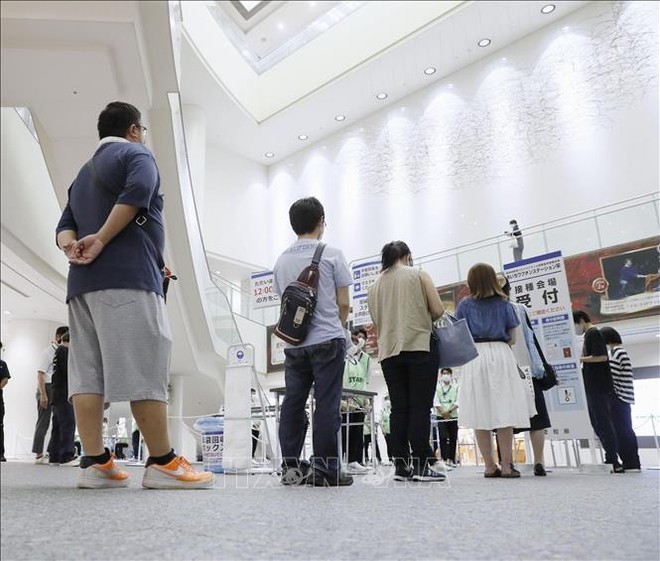 Người dân xếp hàng chờ tiêm vaccine phòng COVID-19 tại Nagoya, Nhật Bản. Ảnh: Kyodo/TTXVN