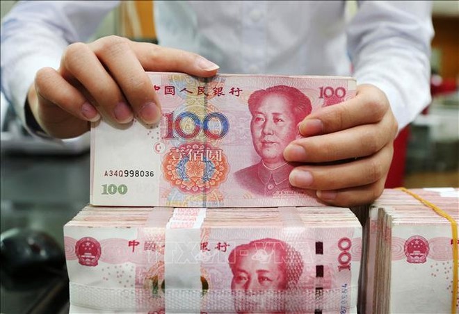 Kiểm tiền mệnh giá 100 Nhân dân tệ tại ngân hàng ở tỉnh Giang Tô, Trung Quốc. Ảnh tư liệu: AFP/TTXVN