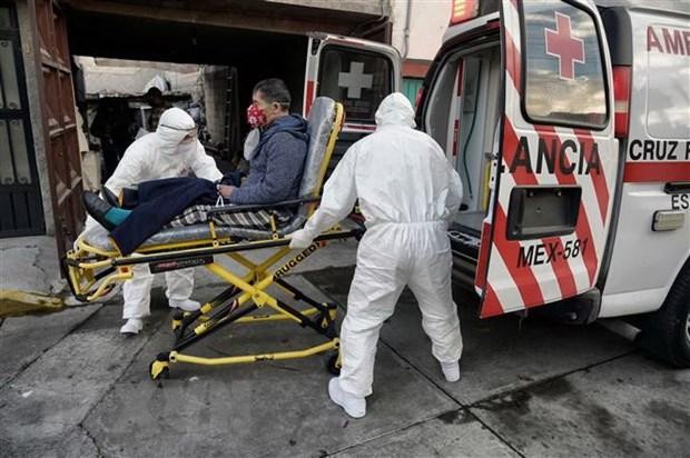 Nhân viên y tế chuyển bệnh nhân nhiễm COVID-19 lên xe cứu thương tại Toluca, Mexico. (Ảnh: AFP/TTXVN).