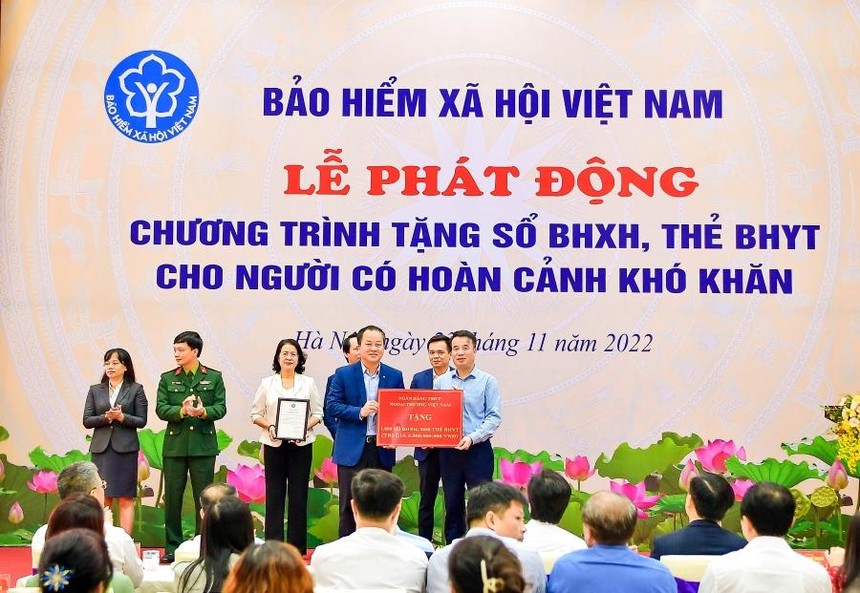 Phó Tổng Giám đốc Vietcombank Nguyễn Việt Cường (hàng đầu, bên trái) trao biểu trưng tặng 1.000 sổ BHXH, 9.968 thẻ BHYT với tổng trị giá 5 tỷ đồng cho đại diện BHXH Việt Nam.