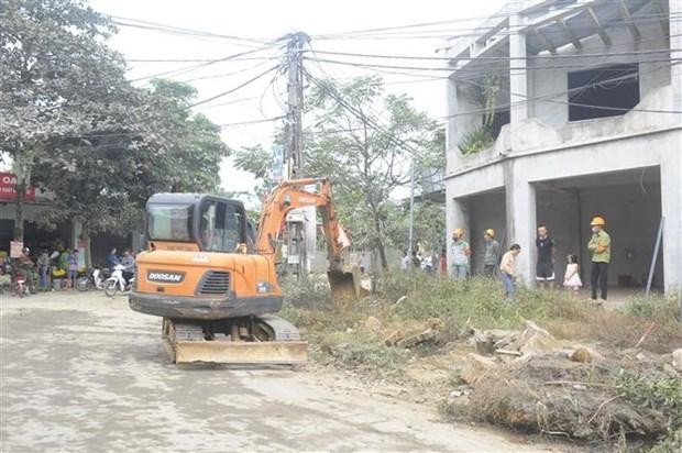 Huyện Ba Vì (Hà Nội) huy động phương tiện cơ giới thực hiện cưỡng chế tháo dỡ, cây, tường rào...trong phạm vi giải phóng mặt bằng. (Ảnh Mạnh Khánh/TTXVN).